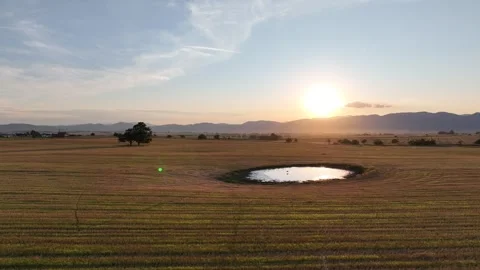 A large puddle of water in the middle of a field in a picturesque landscape Stock Footage 284745041