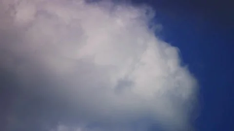 Large puffy clouds moving against a deep blue sky Stock Footage 329759011