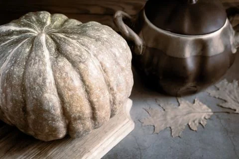 A large pumpkin next to a ceramic pot Stock Photos