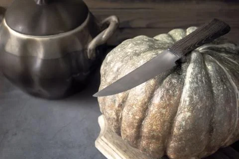 A large pumpkin next to a ceramic pot Stock Photos