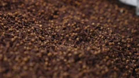A large quantity of brown cloves are piled on a surface for display. Video stock 328026851
