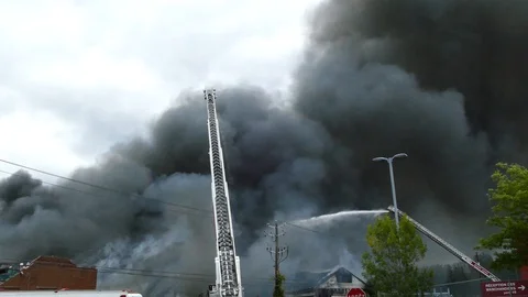 Large quantity of dark grey smoke rising up from a building fire Vidéo 97683453