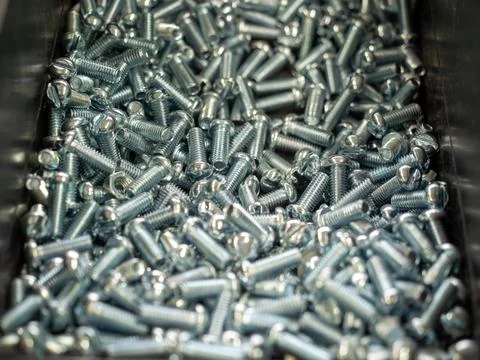 Large quantity of zinc-plated machine screws in industrial bin Stock Photos