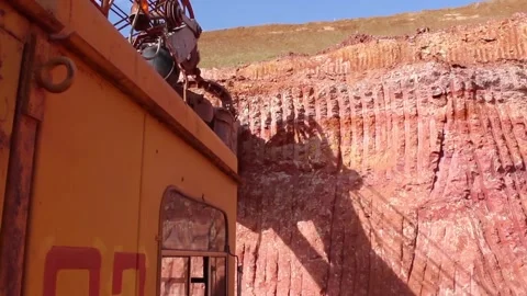 A large quarry excavator loads a huge quarry dump truck with soil. View from the Stock Footage 122214616