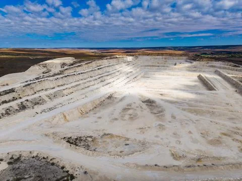 Large quarry located in an open landscape with multiple layers and trucks i.. Stock Photos