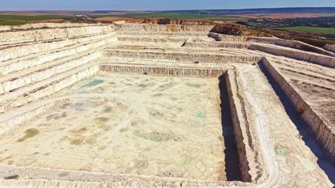 Large quarry in an open area with distinct layers and patterns during bright Vídeos de archivo 341077392