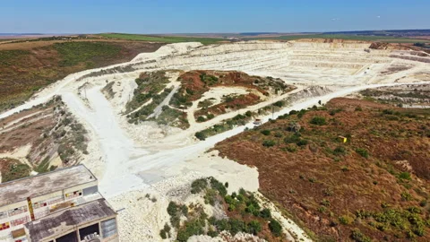 Large quarry site with multiple levels and heavy machinery in use during the day Stock Footage 341075560