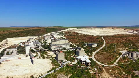Large quarry site with processing facilities and machinery in operation during Video stock 341075867