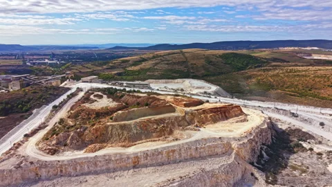 Large quarry site showing mining operations and machinery in a rural area during Stock Footage 345455176