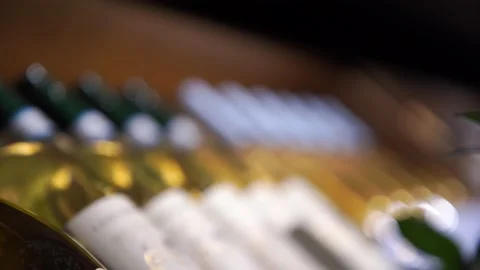 A large rack with bottles of wine lying in a row one after another in restaurant Stock Footage 164961504