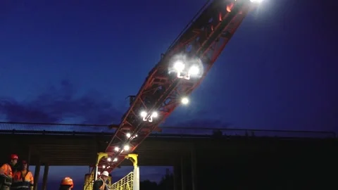 Large rail construction machine illuminated at night with workers on-site Stock Footage 313470115