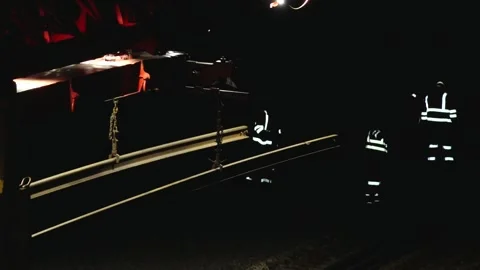 Large rail construction machine illuminated at night with workers on-site Stock Footage 313470151