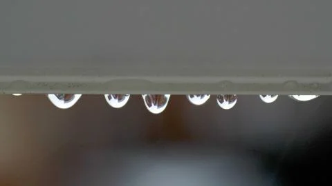 Large rain drops strike open window pane during heavy shower in England Stock-Fotos