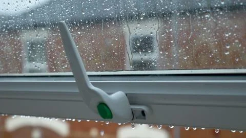 Large rain drops strike open window pane during heavy shower in England Photos