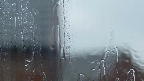Large rain drops strike open window pane during heavy shower in England Photos