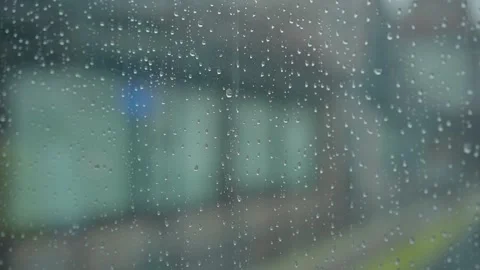 Large rain drops strike a window pane during a summer shower Stock Footage 131840648