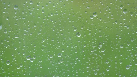 Large rain drops strike a window pane during a summer shower. Stock Footage 200862493