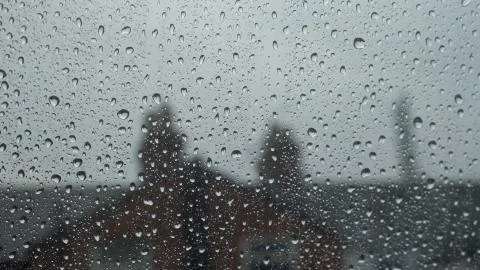 Large rain drops strike a window pane during heavy shower in England Stock-Fotos