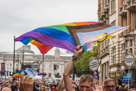 Large rainbow flag waving over the crowd at London Pride parade. London, UK, 29 Stockfoto's