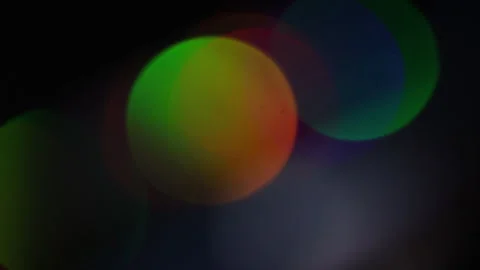 Large rainbow light bokeh moving in the dark Vidéo 309494503