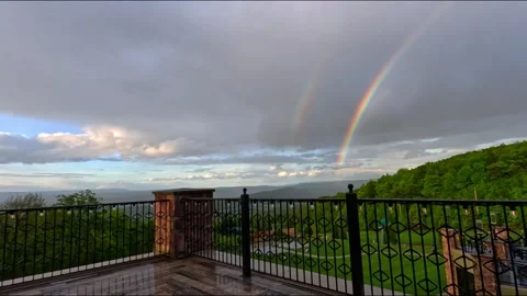 A large rainbow over a green forest on a rainy day, Pennsylvania. Stock Footage 332591138