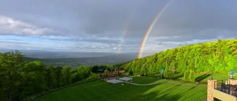 A large rainbow over a green forest on a rainy day, Pennsylvania. Stock Footage 332591159