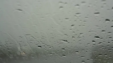 Large raindrops fall on automobile windshield against cars Stock Footage 121511753