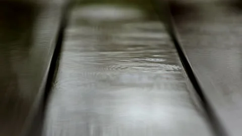 Large raindrops fall on brown decking floor. Stock Footage 141949221