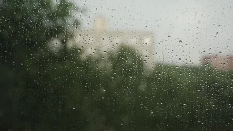 Large raindrops on the window during the rain against the background of the city Vídeo Stock 337073229
