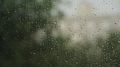 Large raindrops on the window during the rain against the background of the city Stock Footage 337073343