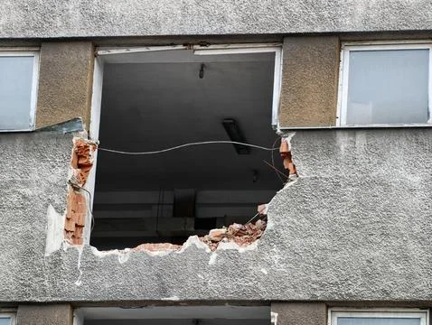 Large rectangular hole in concrete building facade revealing interior ceiling Stock Photos