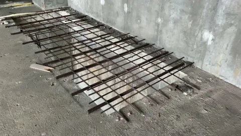 A large rectangular hole in the concrete floor is blocked by an iron grating at Stock Footage 166375453