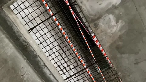 A large rectangular opening in the concrete floor is covered with an iron Stockbeeldmateriaal 165087251