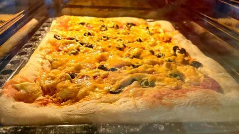 Large rectangular pizza in the oven. Homemade pizza. Stock Photos