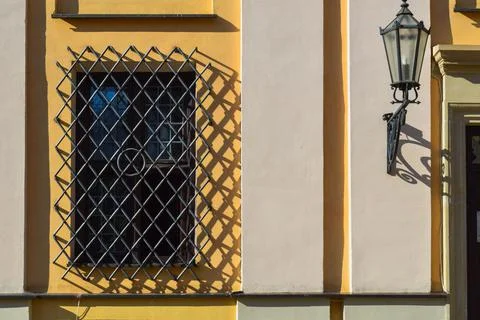 A large rectangular window of a yellow stone building closed by a large black Stock Photos