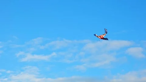 Large red and orange kite in shape of the Koi carp flying high in clear blue Stock Footage 347956659