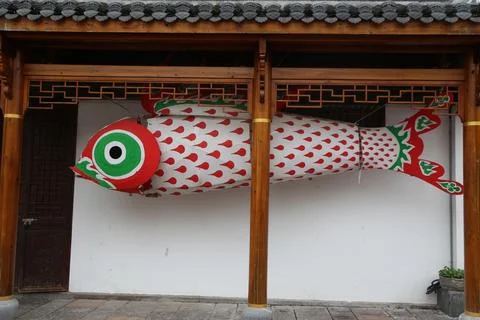 Large red and white fish lantern hanging beneath a wooden traditional style.. Stock Photos
