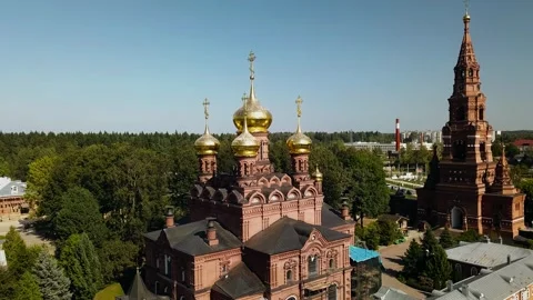 A large red brick temple with golden domes against a blue sky Stock Footage 304991815