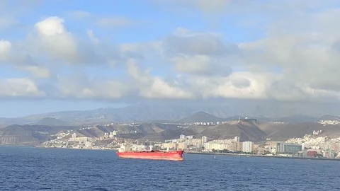 Large red cargo ship sailing the sea near a large port Stock Footage 210214039