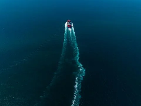 Large Red Cargo Vessel Navigating Through Deep Blue Ocean Waters High Angle.. Stock Photos