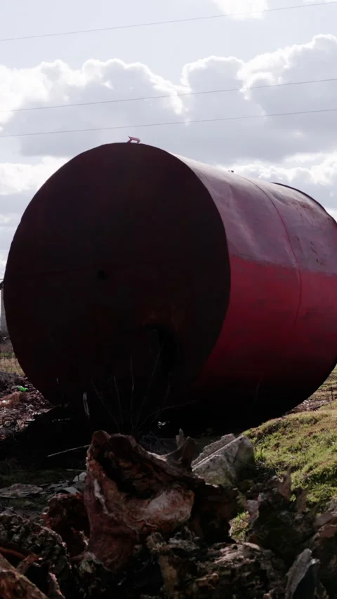 Large red cylindrical tank positioned on uneven ground with visible rust and 스톡 동영상 340274006
