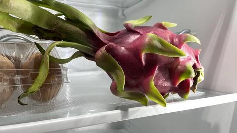 Large red dragonfruit in a refrigerator, white background. Foto stock