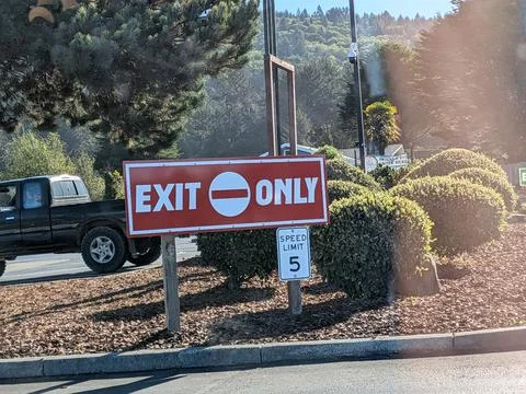 Large red “EXIT ONLY” sign and “SPEED LIMIT 5 MPH” sign Stock Photos