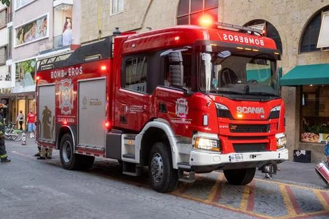Large Red Fire Engine on a Busy Downtown Street with Buildings and Pedestrians Foto stock