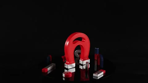 Large red horseshoe magnet rotating with smaller magnetic shapes on black s.. Stock-Footage 333492948