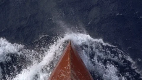 Large red modern vessel bow creates white foaming waves Stock Footage 114766878