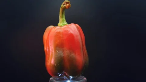 A large red pepper rotates on a black background Stock Footage 117539644