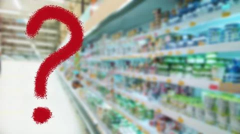 Large red question mark on abstract blur supermarket background. Defocused Stock Photos