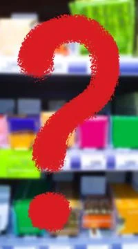 Large red question mark on blur supermarket background. Defocused shelves Stock Photos