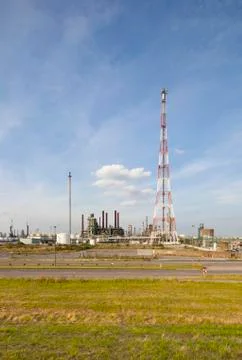 A large refinery complex with flare stack and blue sky. Stock Photos